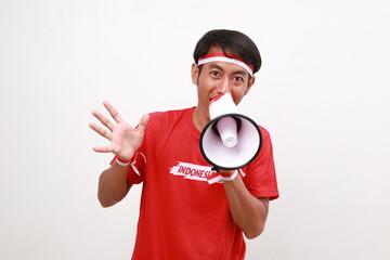 Asian man celebrating Indonesia Independence day, shouting using megaphone. Isolated on white