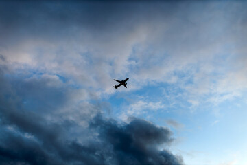 silhouette airplane fly in blue sky with clouds