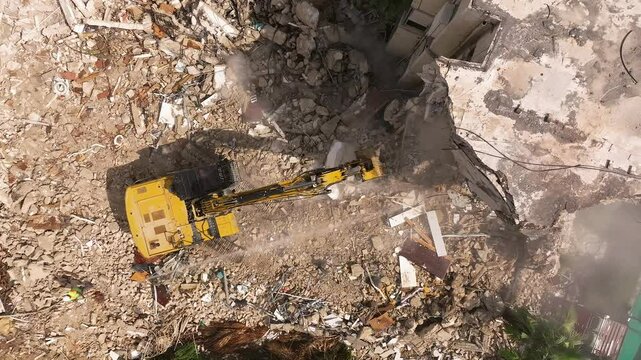 Building demolition excavator using Pulverizer Jaws to demolish a residential building