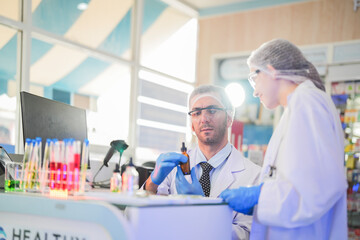 Obraz premium scientists perform experiments and record data. people arranges equipment with test tubes and chemicals for producing medicine and biochemistry. man hold tubes of chemical liquids and plant samples.