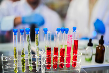 Scientific tubes containing chemicals and plant samples from which substances can be extracted to make medicines for use in humans and animals. With a background as a scientist preparing experiment.
