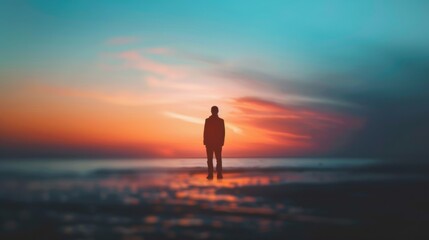 A lone figure stands on a reflective beach at sunset, bathed in vibrant orange, red, and blue hues.