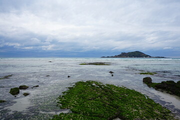 clear shoaling beach and far island