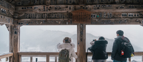 tourist sightseeing view of village with snow in winter from mountain viewpoint of Yamadera temple...