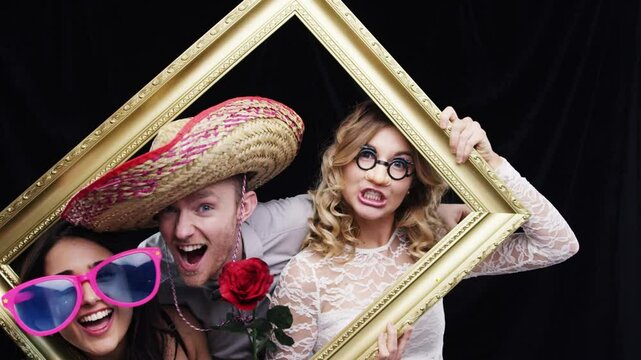 Party people, frame and pose with props doing crazy, comedy and funny pose in photobooth. Friends group portrait at holiday or birthday with comic, laughing and happiness feeling silly and happy