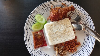 nasi lemak with fried chicken on a plate.