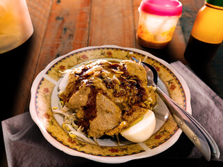 A plate of kupat tahu Bandung. It consist of rice cake (ketupat), tofu, bean sprouts, and hard boiled egg, topped with peanut sauce.