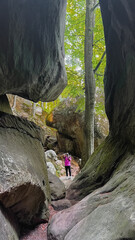 man tourist hiking by rocks on forest