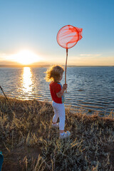 a girl with a net at sunset by the sea of the Volga river