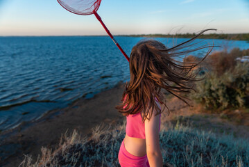 a girl with a net at sunset by the sea of the Volga river