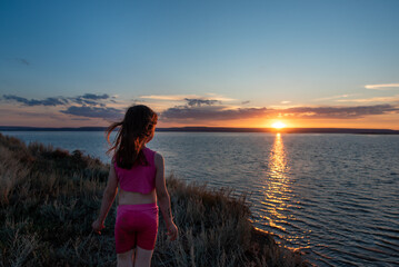 a girl with a net at sunset by the sea of the Volga river
