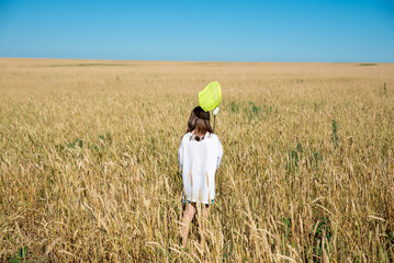 A girl in a wheat field with a net