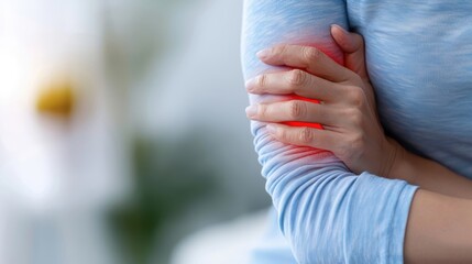 A person grimacing in pain, with a red circle highlighting their inflamed elbow.