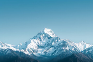 Majestic snow-capped mountain peak under a clear blue sky, showcasing nature's beauty and grandeur.