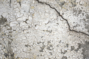 Obsolete backdrop of a cement wall with sun burned while paint, peeling stucco texture, abstract background