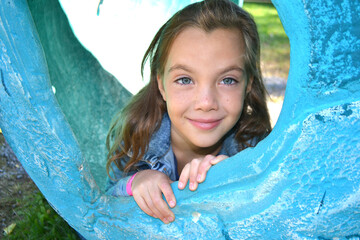 Portrait of the charming girl of 9-10 years. Wind plays with long blonde hair. Serious look of big green eyes. Gentle half-smile. High quality photo