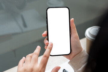A close-up image of an Asian woman using her smartphone while sitting indoors. a smartphone mockup