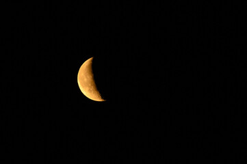 Pomarańczowy półksiężyc na nocnym ciemnym niebie, astrofotografia © Paweł Kacperek