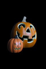 Two jack o lantern pumpkins against a black background 