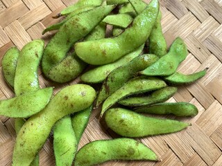 Close up edamame or Glycine max (L.) Merrill isolated on woven bamboo background
