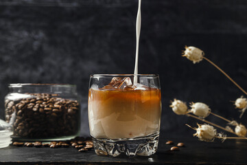 Cold coffee with milk on a dark background. Iced coffee drink