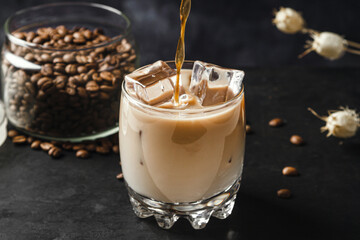 Cold coffee with milk on a dark background. Iced coffee drink