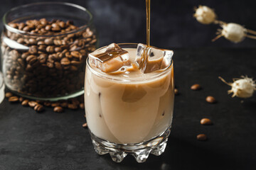 Cold coffee with milk on a dark background. Iced coffee drink