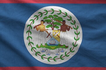 Belize flag depicted on folded wavy fabric of old cloth close up