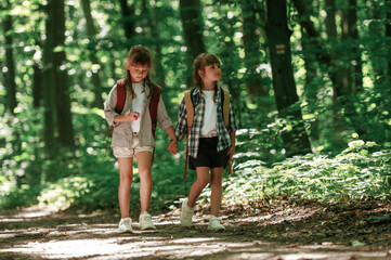 Front view. Kids in forest at summer daytime together