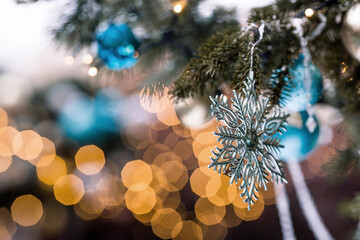 Beautiful festive snowflake decoration on the Christmas tree. Close-up. Beautiful Christmas background. The concept of decorations and decor for the new year. New Year's Card 2025