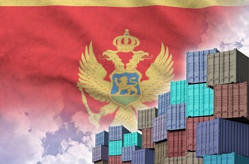 Montenegro flag and big stack of shipping cargo containers in docks with sky background close up