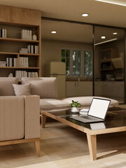 A modern living room featuring a laptop on a coffee table, a comfortable couch, and home decor.