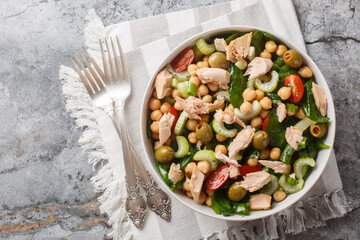 Delicious chickpea tuna salad with healthy ingredients like fresh vegetables and herbs close-up in a bowl on the table. Horizontal top view from above