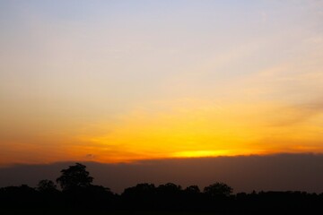 Sunset Sky cloud in the Morning Sunrise with Orange, Yellow Golden Hour Sunrise on Summer season, Horizon Dusk Sky Dramatic Nature Background