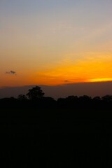 Sunset Sky cloud in the Morning Sunrise with Orange, Yellow Golden Hour Sunrise on Summer season, Horizon Dusk Sky Dramatic Nature Background