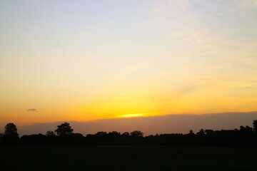 Sunset Sky cloud in the Morning Sunrise with Orange, Yellow Golden Hour Sunrise on Summer season, Horizon Dusk Sky Dramatic Nature Background