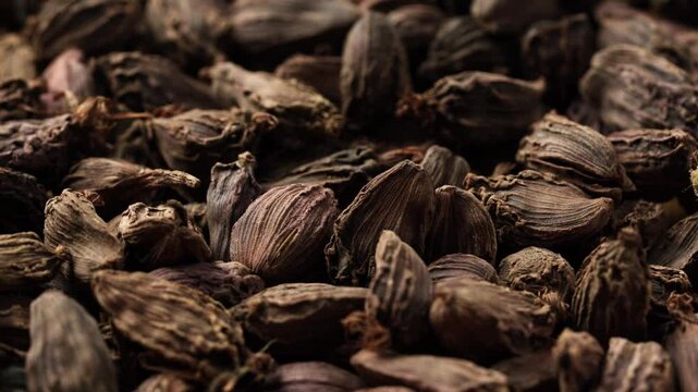 closeup pile of Amomum subulatum or black cardamom texture background circle around food footage rotate