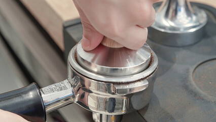 Barista Tamping Ground Coffee in Portafilter
