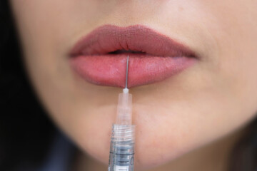 Obraz premium A thoughtful Grecian esthetician gazes into a mirror, her curly hair framing her face. Holding a beauty injection syringe, she contemplates the ideal treatment.