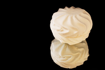 White round marshmallow on a mirror surface.