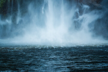 Moody waterfall flowing in tropical rainforest at Milford Sound