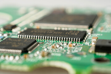 Close-up of ICs, chips, diodes and capacitors on a printed circuit board showing electronic...