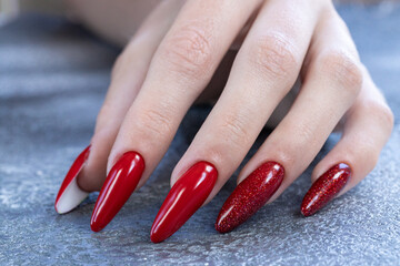 Beautiful red manicure on the nails on the hand. A close-up view