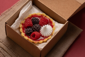 food delivery, sweet dessert with fresh berries in a cardboard box, fresh baked goods to take away