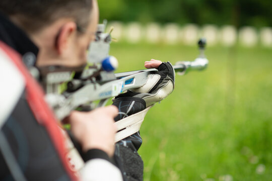 A determined male athlete practices for an upcoming competition with a free rifle, known for his focus, precision, and commitment to excellence in sports shooting.