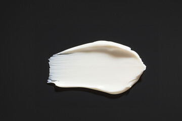 검은 바탕에 묻힌, 문지른 하얀색 크림 화장품