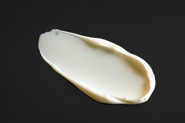 검은 바탕에 묻힌, 문지른 하얀색 크림 화장품