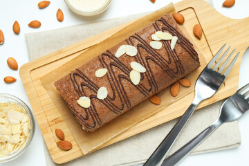 Cake roll with nuts on a wooden board