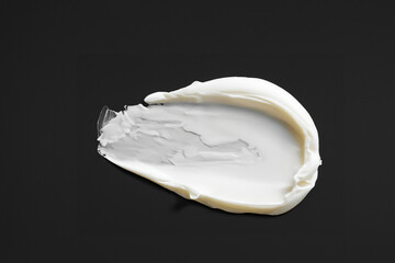 검은 바탕에 묻힌, 문지른 하얀색 크림 화장품