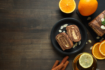 Roll cake in a bowl with fresh oranges on a dark background